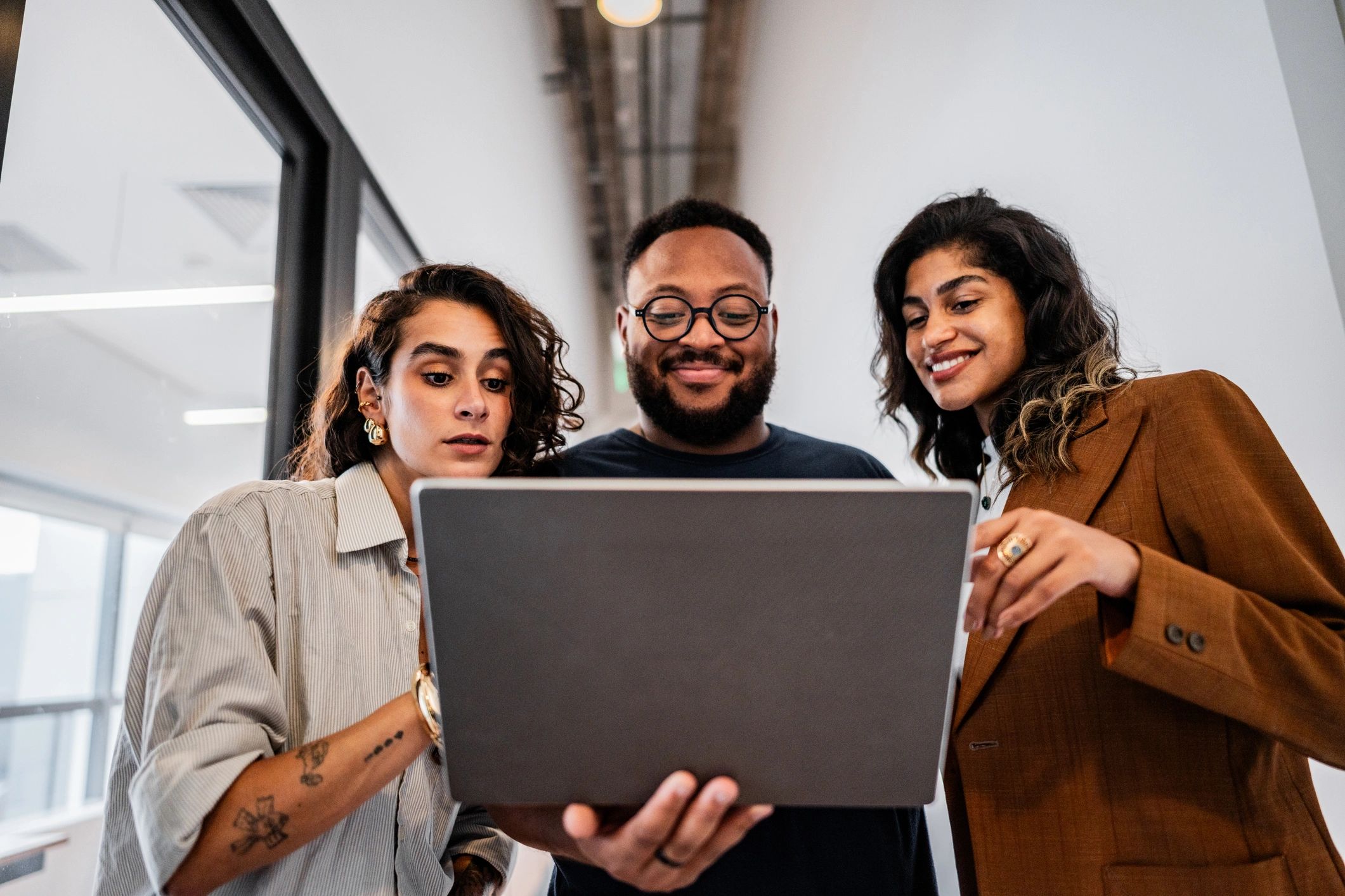 Coworkers discussing results while using a laptop